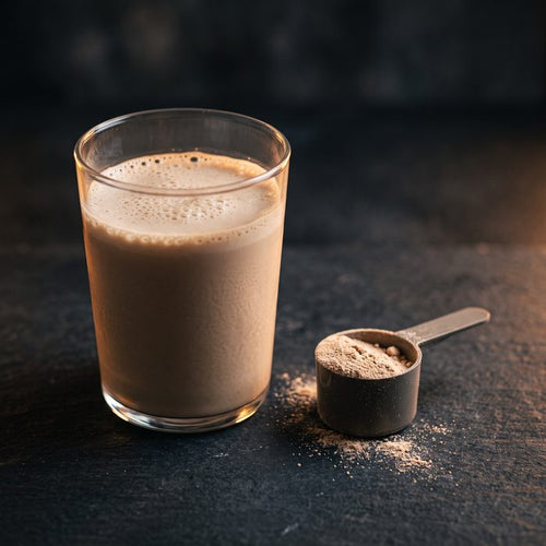 Frisch zubereiteter Proteinshake in einem Glas neben einem Messlöffel